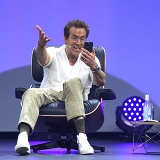 Ryan Reynolds, Schauspieler, Unternehmer und Mitbesitzer des walisischen Fußballclubs Wrexham AFC, telefoniert auf der Bühne mit seinen Kindern während der Digital- und Marketingmesse OMR in den Messehallen.